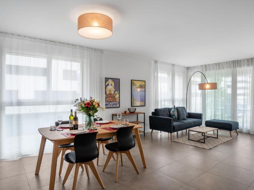 uma sala de estar com uma mesa de jantar e cadeiras em Apartment LocTowers A3-6-3 by Interhome em Locarno