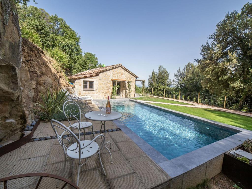 una piscina con mesas y sillas junto a una casa en Chalet Il Talamo by Interhome, en Castel Rigone