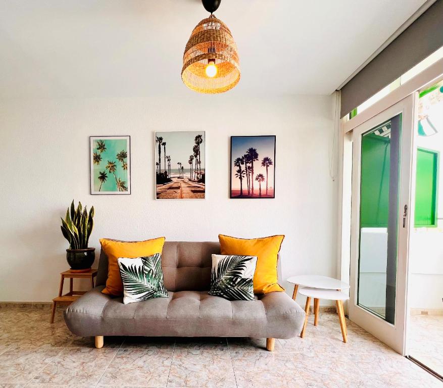 sala de estar con sofá y almohadas amarillas en Apartment Palm trees view of the dunes en Playa del Ingles