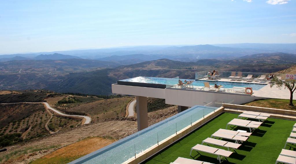 une maison au sommet d'une colline avec une piscine dans l'établissement Hotel & Spa Alfandega da Fe, à Sambade