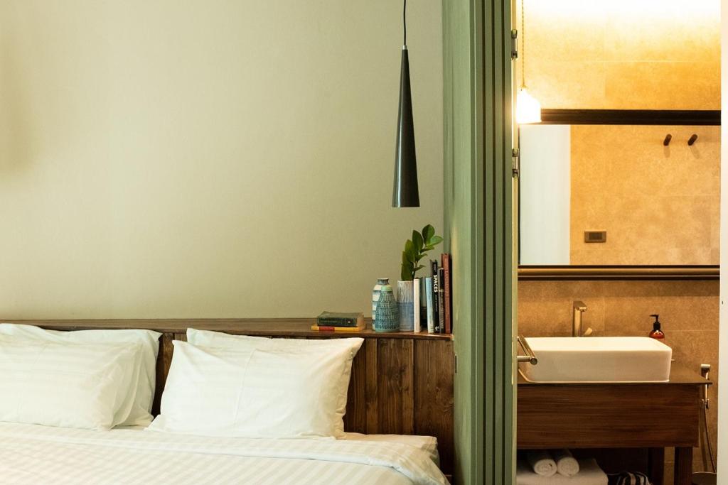 A partial bedroom view showing the bed beside an open vanity area.