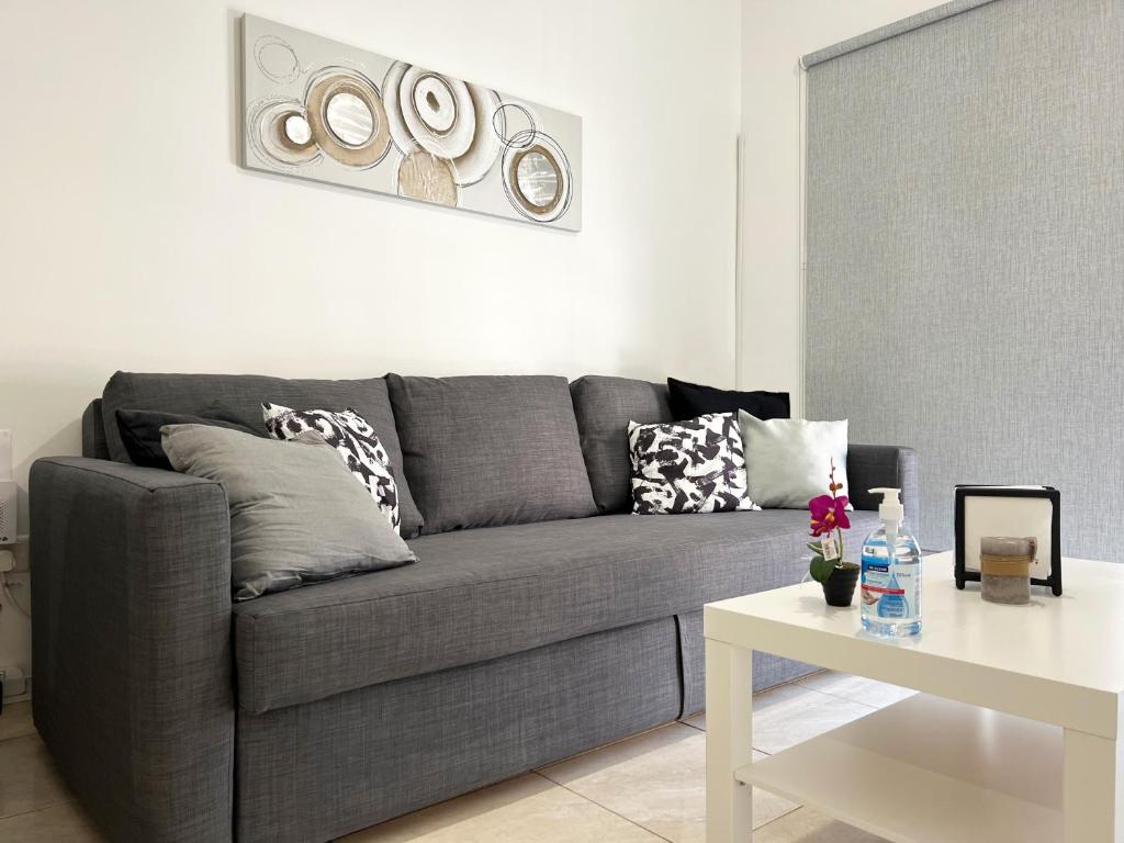 a living room with a gray couch and a table at Albert's apartment Marina 15 in Larnaca