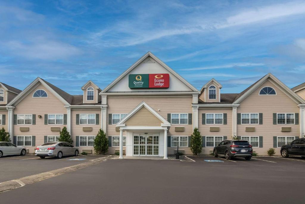 a large building with cars parked in a parking lot at Econo Lodge Auburn I-95 in Auburn