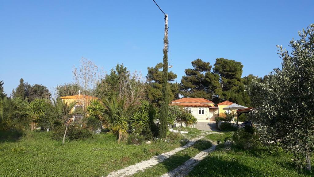 een huis in het midden van een veld met bomen bij Beautiful Cottage sea view near the beach Greece in Lixouri