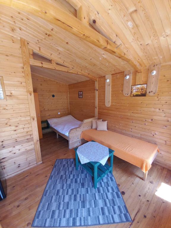 a room with two beds in a wooden cabin at Вилно селище МИРОВЕЦ in Malŭk Izvor