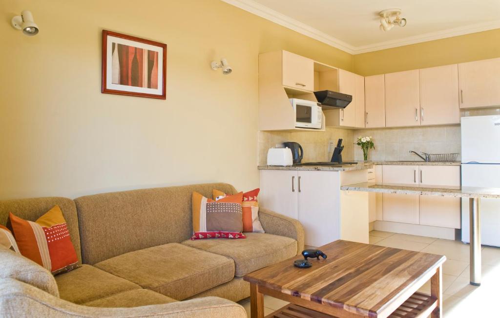 ein Wohnzimmer mit einem Sofa und einem Tisch in der Unterkunft Shakespeare Court Serviced Apartments in Lusaka