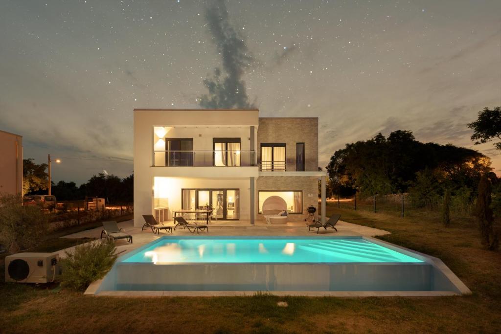 eine Villa mit einem Pool vor einem Haus in der Unterkunft Villa Monte D'Or in Krnica