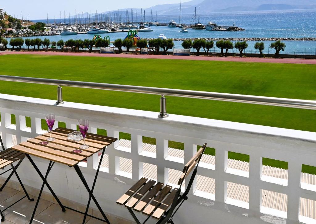 a table and chairs on a balcony with a view of the water at Efi's Luxury Suite in Agios Nikolaos
