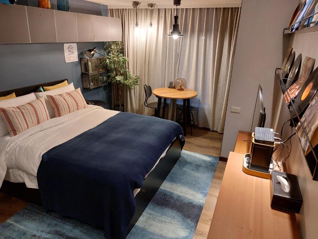 a bedroom with a bed and a table in it at Yomi Hotel - ShuangLian MRT in Taipei