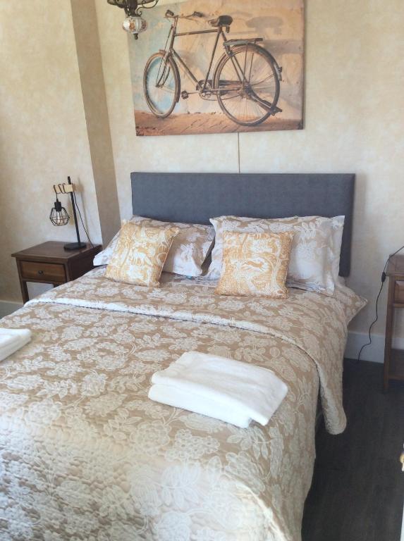una camera da letto con un letto con una bicicletta appesa al muro di Maison Les Berrys a Bourganeuf