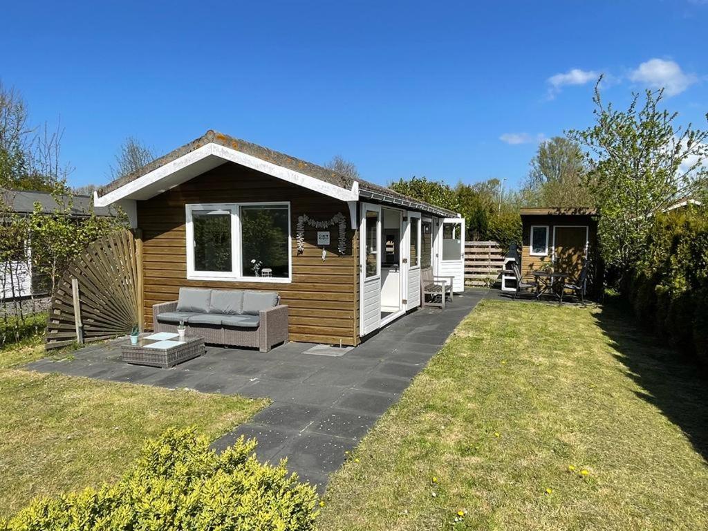 een kleine hut met een patio in een tuin bij Rekerlanden 253 in Schoorldam