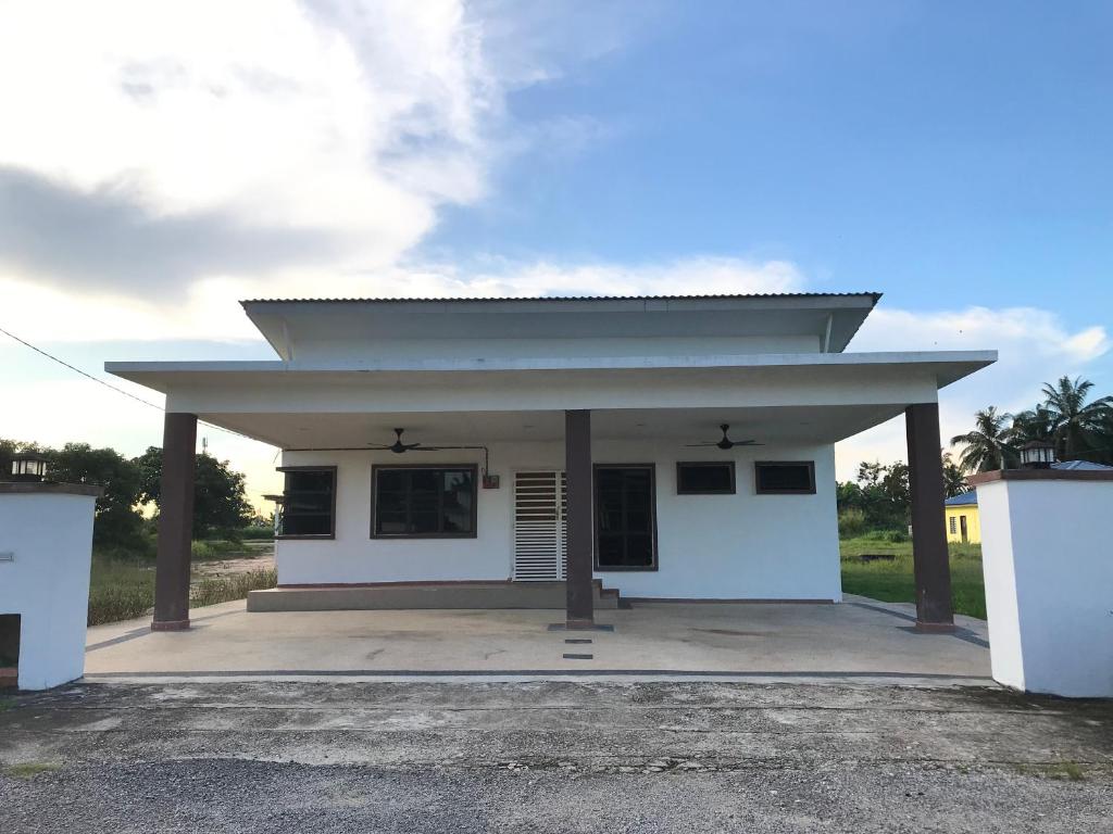 un pequeño edificio blanco con techo en D` Totok HouseStay, en Sepang