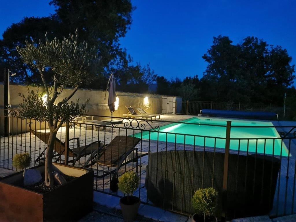 une piscine dans une cour la nuit dans l'établissement Le Gîte du Mas Amouroux, près du Mont Bouquet, à Les Plans