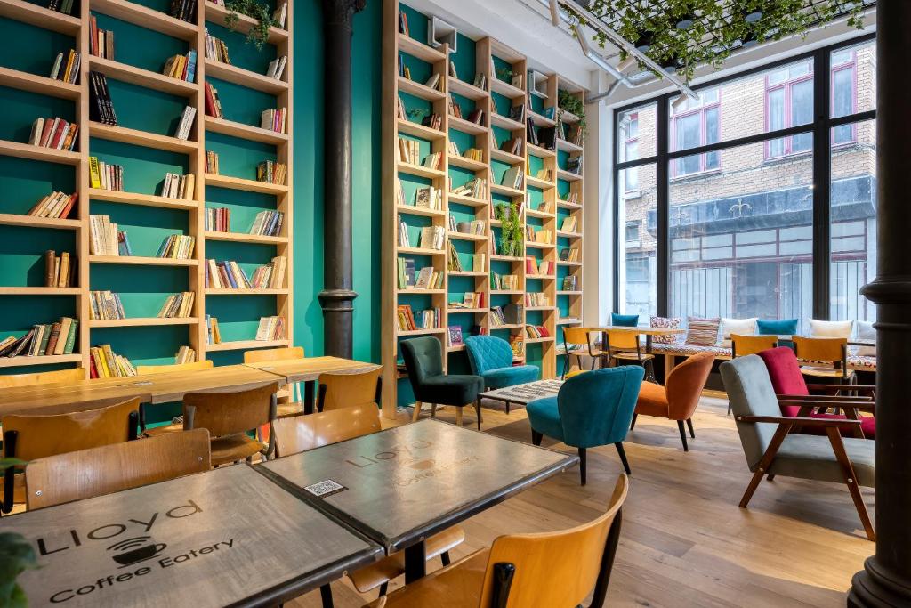 biblioteca con mesas, sillas y estanterías en Aris Grand Place Hotel, en Bruselas