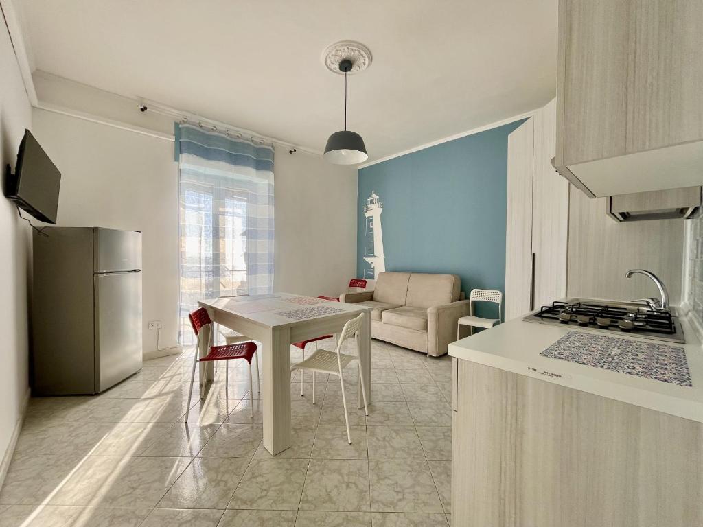 een keuken en een woonkamer met een tafel en een koelkast bij the Lighthouse in Castellammare di Stabia