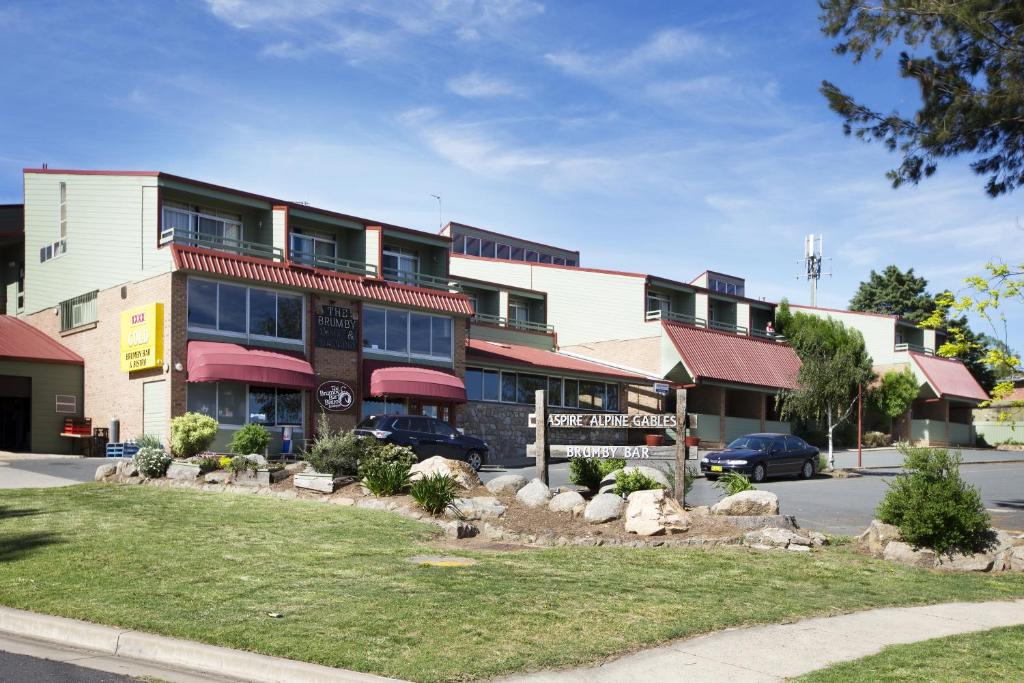 a building on a street with cars parked in front at Alpine Gables in Jindabyne