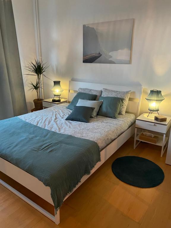 sypialnia z dużym łóżkiem z niebieskimi poduszkami w obiekcie Appartement de charme dans maison de maître bruxelloise w Brukseli