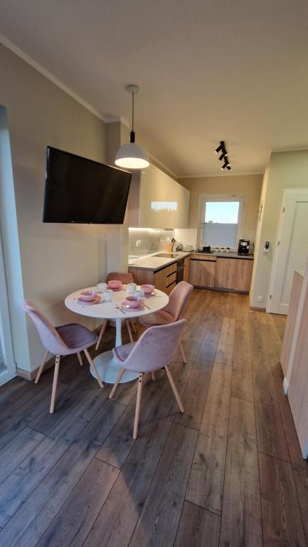 salon ze stołem i krzesłami oraz kuchnię w obiekcie Apartament Golf & Nature - Na Polu Golfowym w mieście Sobienie Biskupie