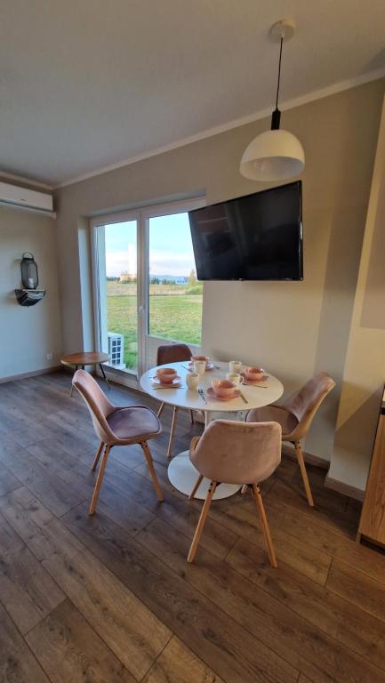 jadalnia ze stołem, krzesłami i telewizorem w obiekcie Apartament Golf & Nature - Na Polu Golfowym w mieście Sobienie Biskupie