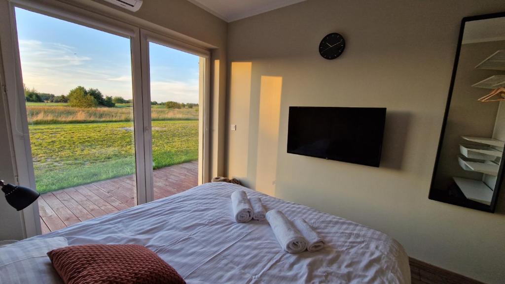 sypialnia z łóżkiem i dużym oknem w obiekcie Apartament Golf & Nature - Na Polu Golfowym w mieście Sobienie Biskupie