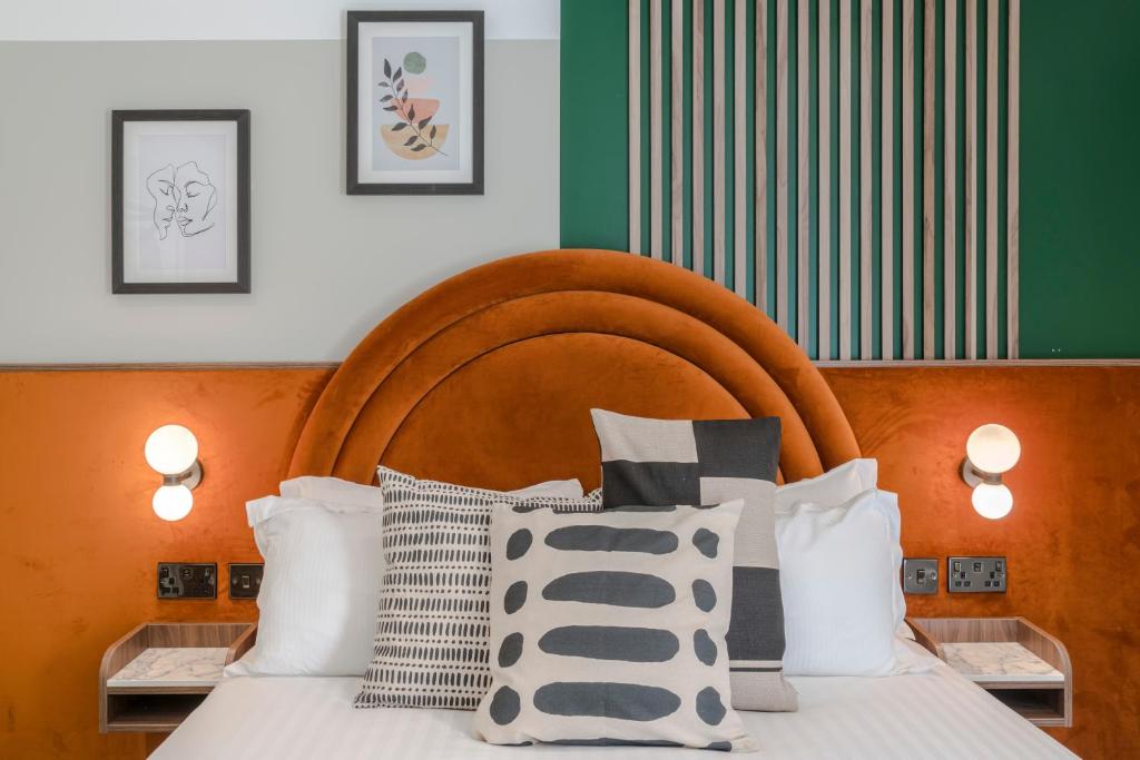 een slaapkamer met een bed met een houten hoofdeinde en kussens bij Your Apartment I Arabica House in Bristol