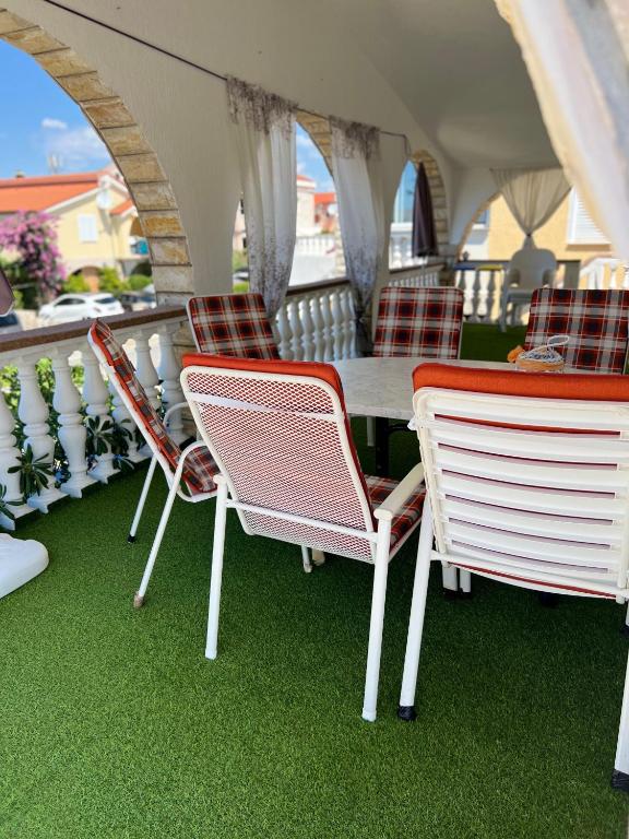 grupa krzeseł i stół na balkonie w obiekcie Apartman Tunja w mieście Vir