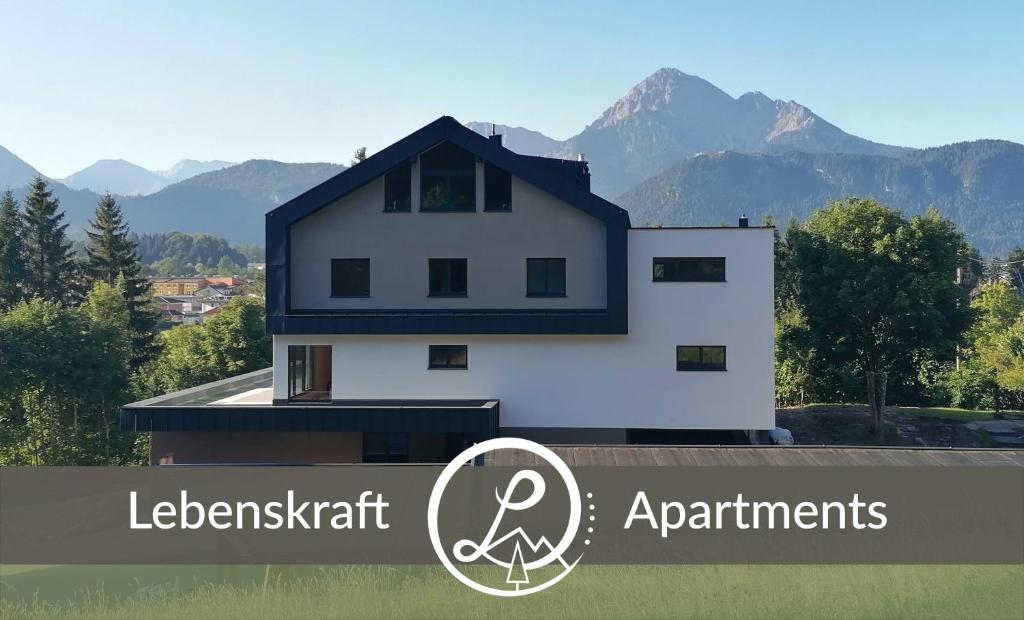 a white house with mountains in the background at Lebenskraft-Apartments in Reutte