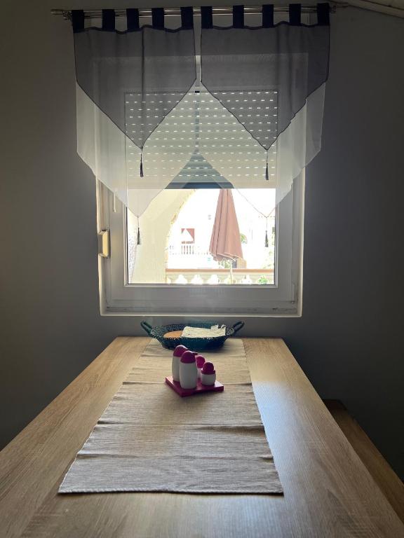 stół z oknem i talerzem jedzenia w obiekcie Apartman Tunja w mieście Vir
