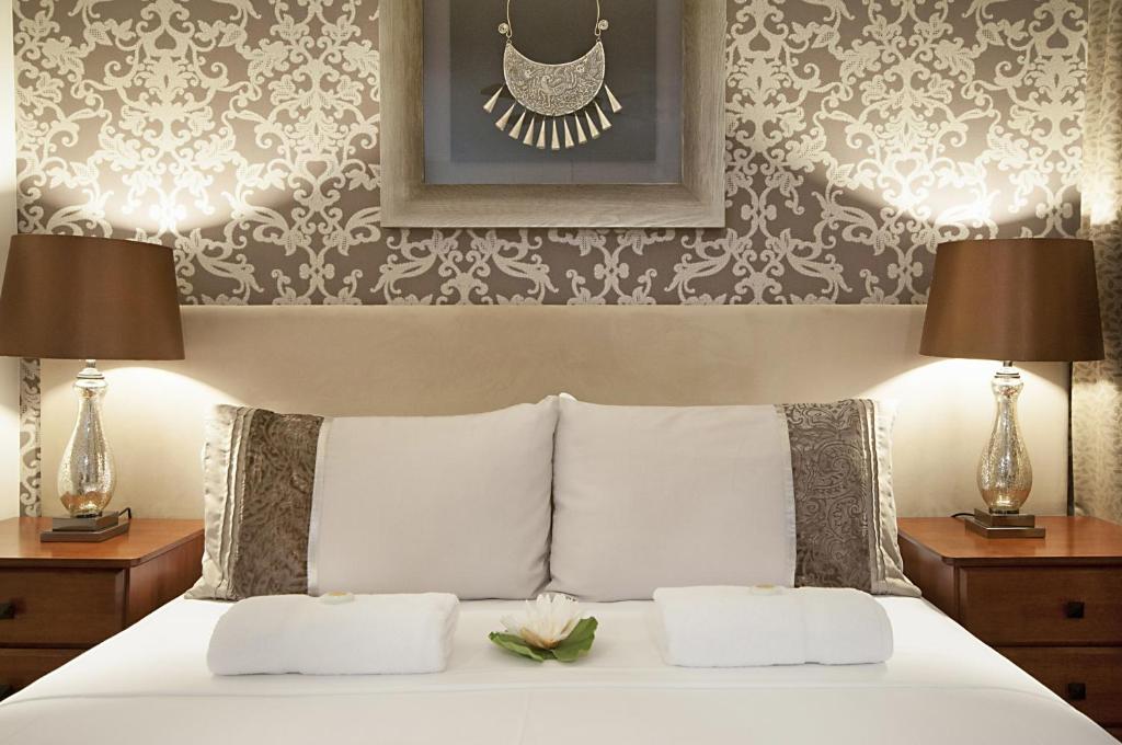 a bedroom with a white bed with two lamps at Ballina Travellers Lodge in Ballina