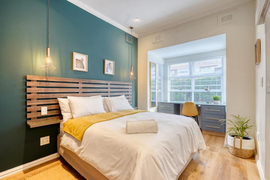 um quarto com uma cama grande e uma parede azul em Hampton Collection - Charming 1 or 2 Bedroom Apartment with Pool em Durban