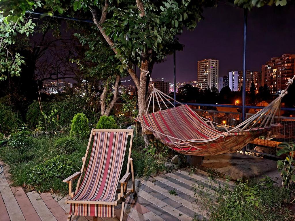 a hammock and two chairs sitting next to a tree at Green Garden - Crimea in Tbilisi City