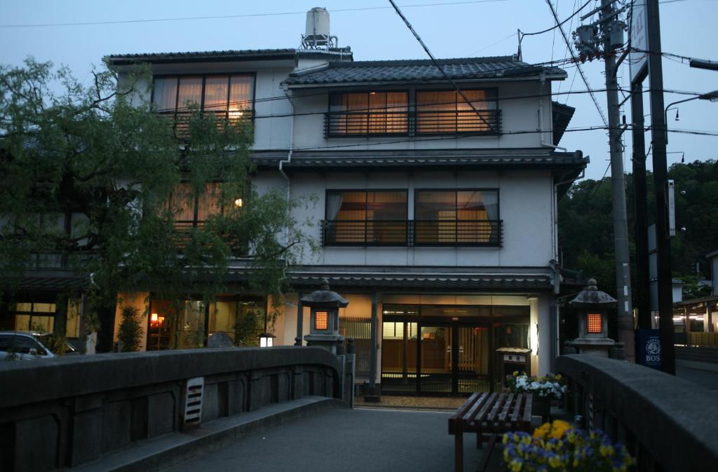 a building with a bench in front of it at Kinosaki Onsen Kawaguchiya Honkan in Toyooka
