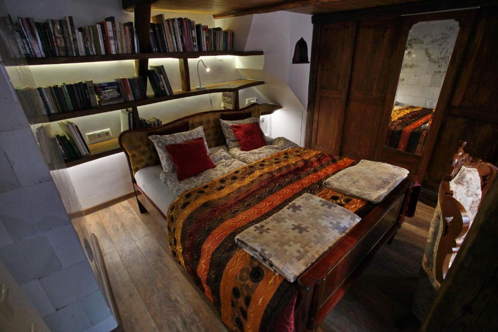 een slaapkamer met een bed en een boekenplank bij Medieval Super Studio in Vilnius