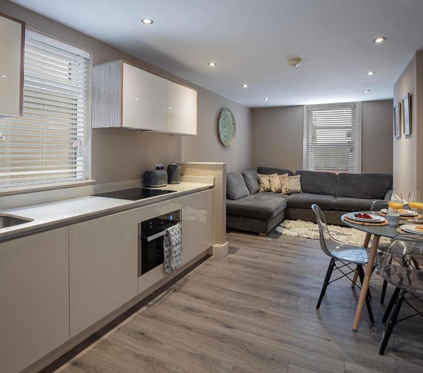 a kitchen and living room with a couch and a table at Coral Boutique Apartment 2 in Blackpool