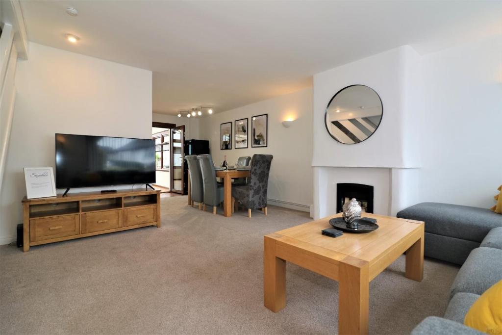 a living room with a flat screen tv and a fireplace at Signature - Barons Court in Paisley