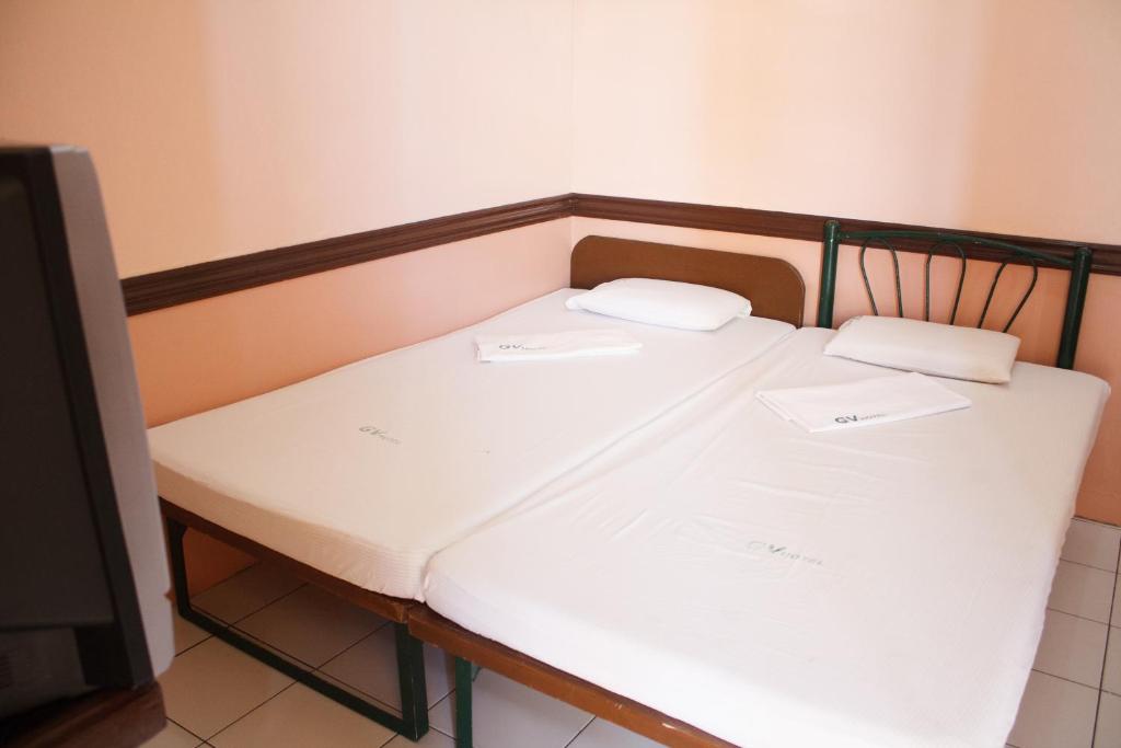 Una cama con dos almohadas blancas encima. en GV Hotel - Catarman, en Catarman