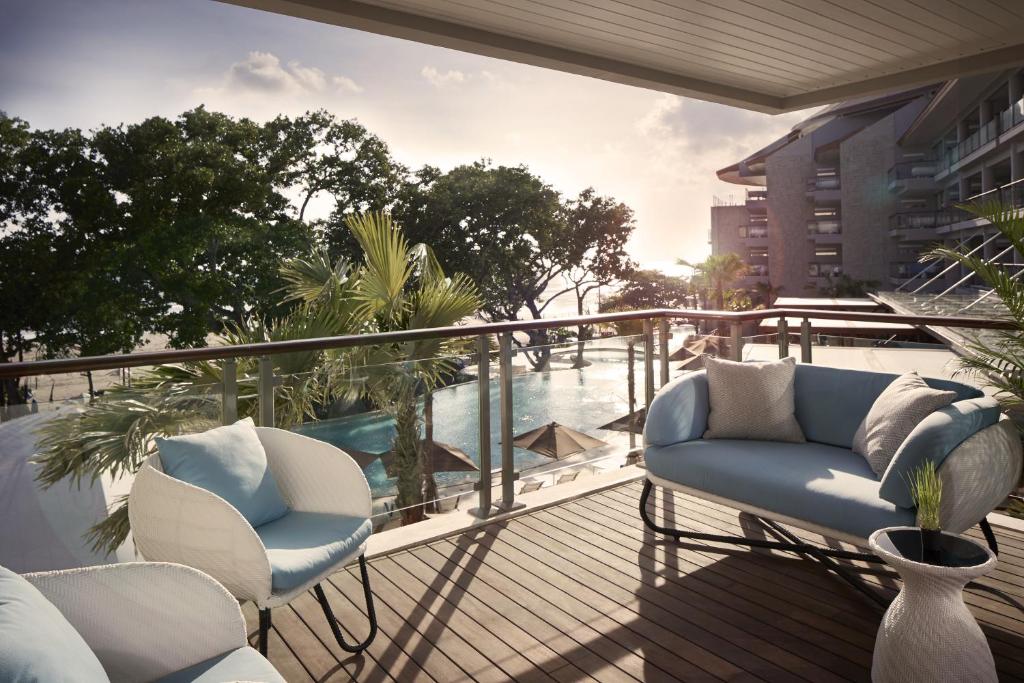 a balcony with chairs and a view of the water at Double - Six, Luxury Hotel - Seminyak in Seminyak