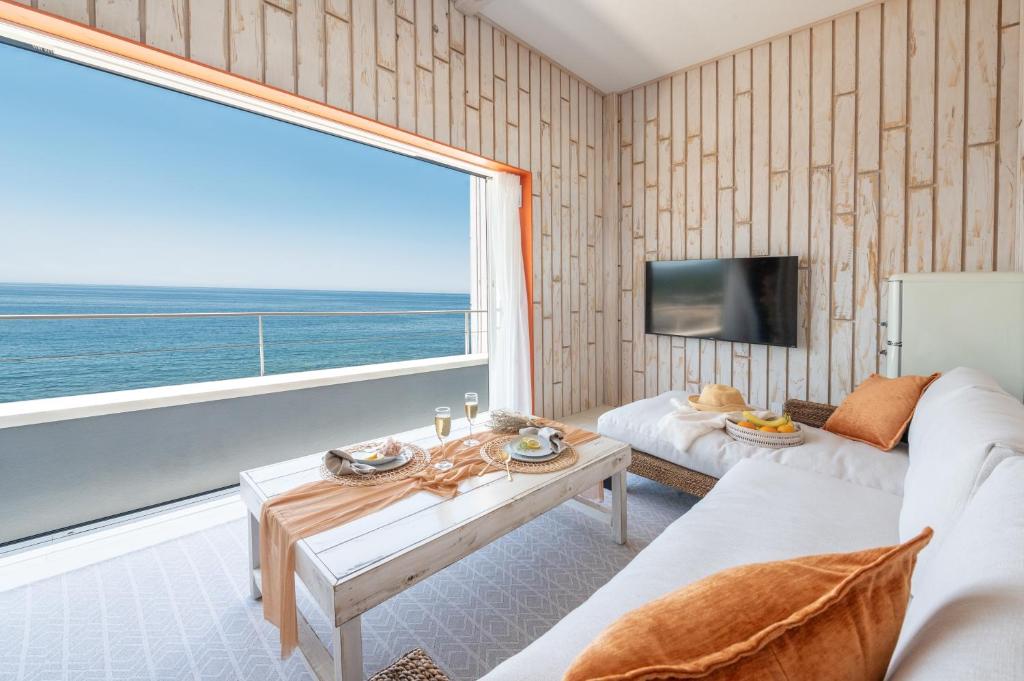 - un salon avec un canapé blanc et une grande fenêtre dans l'établissement Sunset & Villa Spa Resort, à Fukui