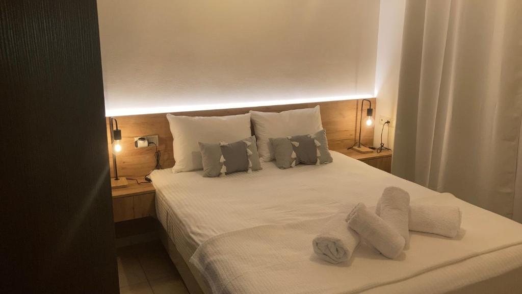 a bedroom with a bed with white sheets and pillows at Bright Luxury Apt. in Volos
