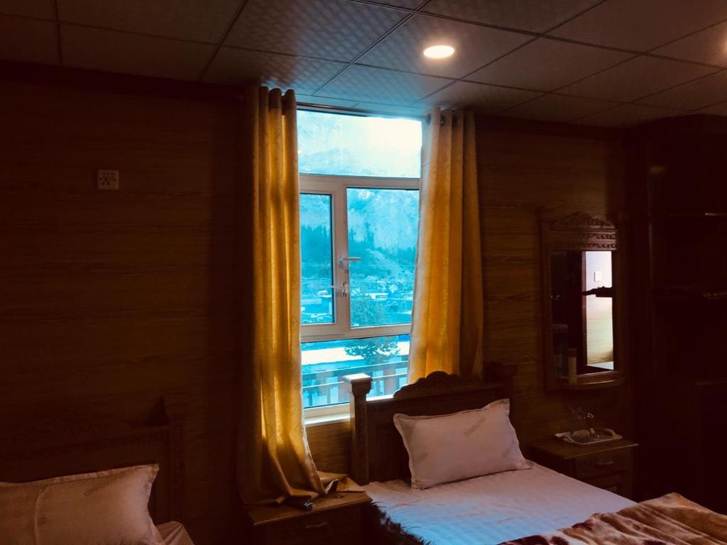 a bedroom with a bed and a large window at Gems Palace Hotel Sost in Gircha