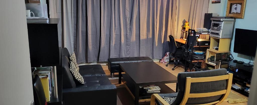 sala de estar con mesa, sillas y escritorio en Double room in a cosy flat in Tooting, en Londres