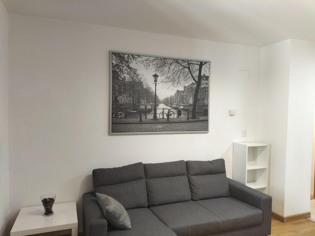 sala de estar con sofá y una foto en la pared en La Cabañera Canfranc Estación, en Canfranc-Estación
