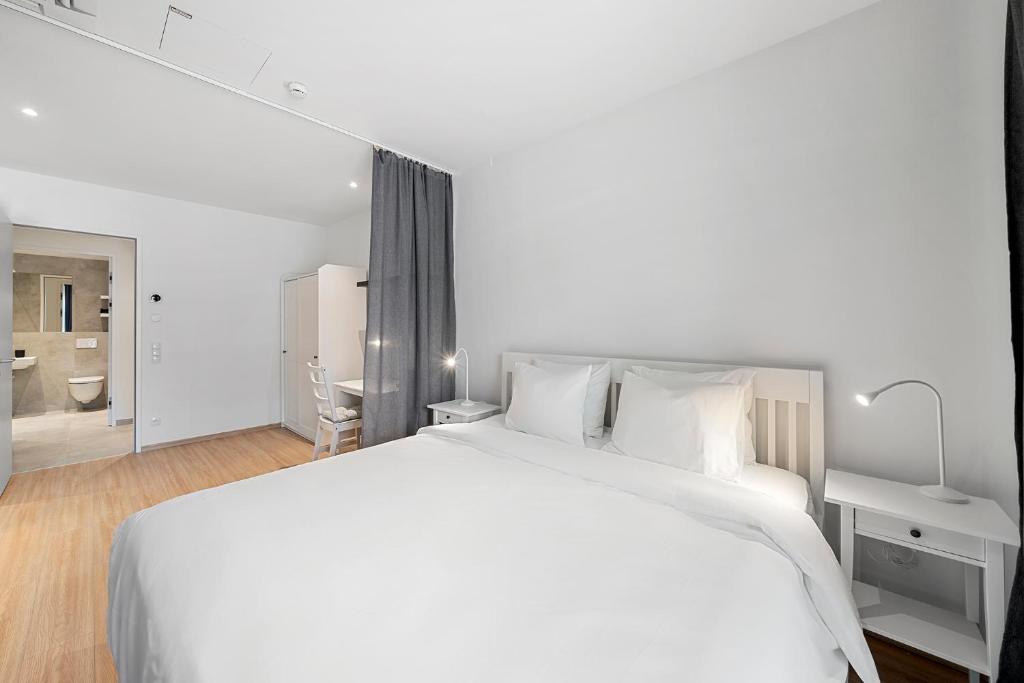 biała sypialnia z dużym łóżkiem i łazienką w obiekcie VibeStudio 302 - Central - AC - Near Parking w Wiedniu