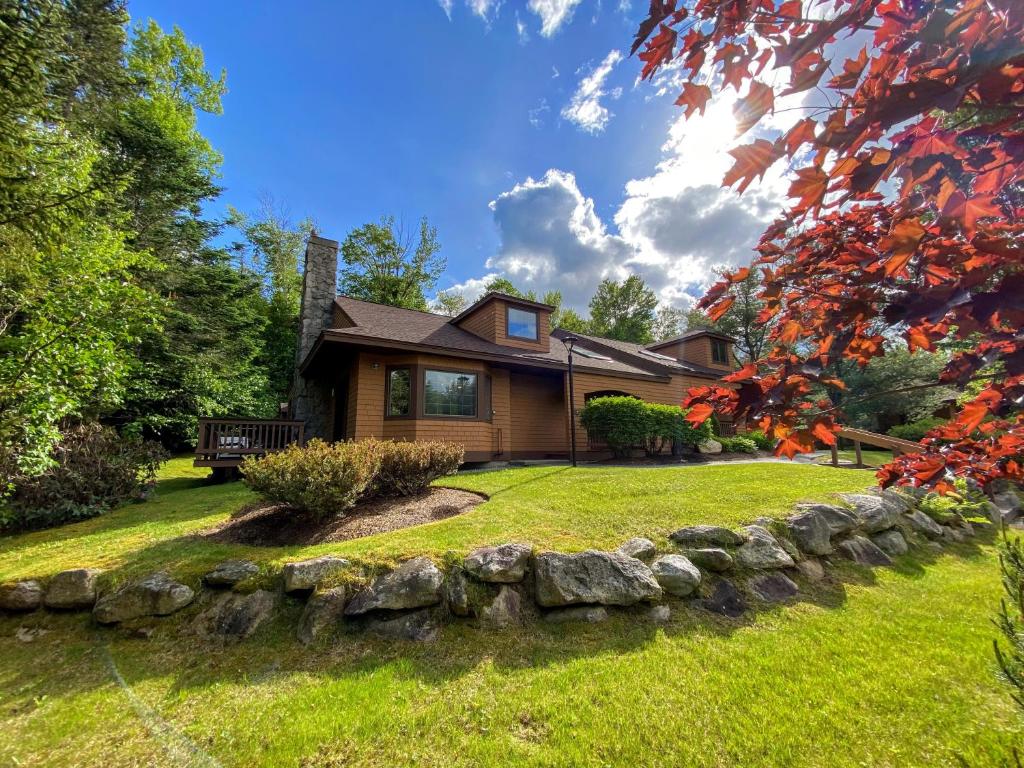 una casa con una pared de piedra en frente de un patio en O9 NEW Renovated Bretton Woods slopeside condo with 2 living rooms foosball air hockey, en Carroll