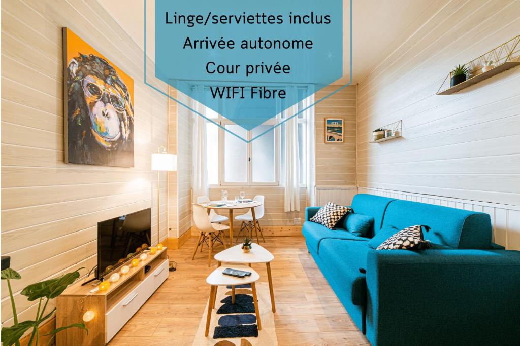 uma sala de estar com um sofá azul e uma mesa em Centre historique - Cour privée - Arrivée autonome em Agen