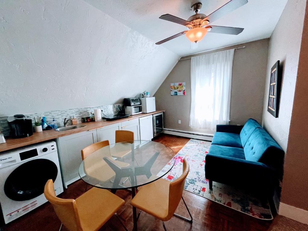a living room with a glass table and a blue couch at Executive Suite Loft - Harvard Allston Campus in Boston