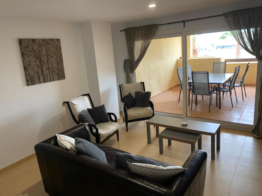 sala de estar con sofá, sillas y mesa en Casa Moriarty, en Murcia