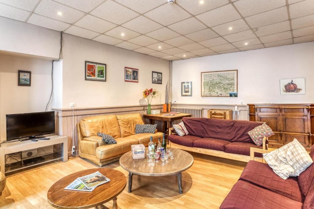 un salon avec des canapés et une télévision dans l'établissement Maison spacieuse à Bagnères-de-Luchon près des pistes, idéale., à Luchon