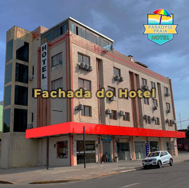 a building with a sign for a hotel at Hotel Paradyse Praia in Capão da Canoa