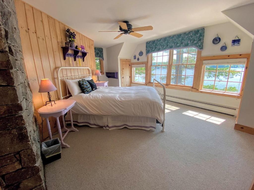 sypialnia z łóżkiem i wentylatorem sufitowym w obiekcie FL Quintessential LAKE HOUSE close to Bretton Woods Santas Village and Forest Lake State Park w mieście Whitefield